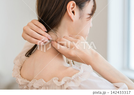 パールネックレスを身につける女性の手元 パールネックレスを身につける女性の手元 142433317