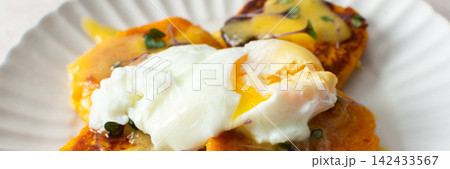 Millet pancakes are served on a plate with hollandaise sauce and a poached egg. This meal is ideal for anyone looking for a healthy breakfast or lunch option, banner Millet pancakes are served on a plate with hollandaise sauce and a poached egg. This meal is ideal for anyone looking for a healthy breakfast or lunch option, banner 142433567