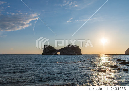 夕暮れの海に浮かぶ円月島と夕日の輝き 142433628