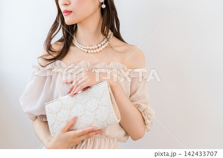 パーティーバッグを持つドレスアップした女性 パーティーバッグを持つドレスアップした女性 142433707