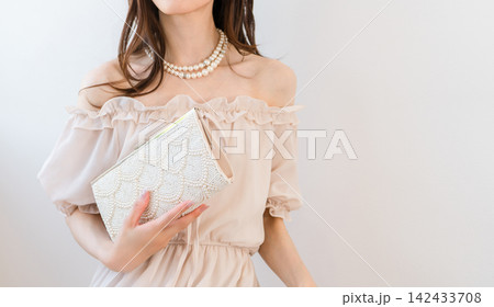 パーティーバッグを持つドレスアップした女性 142433708