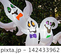 Three illuminated inflatable ghost decorations create a playful Halloween display outdoors. The colorful ghosts bring fun seasonal spirit to a residential neighborhood. 142433962