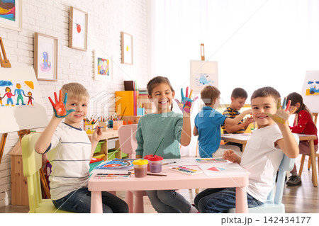 Cute little children with painted palms in room 142434177