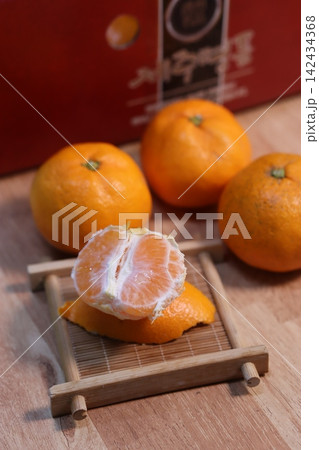 Fresh Peeled Oranges and Whole Citrus Fruits on Wooden Surface Fresh Peeled Oranges and Whole Citrus Fruits on Wooden Surface 142434368