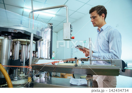 Focused male engineer using digital tablet on factory production line 142434734