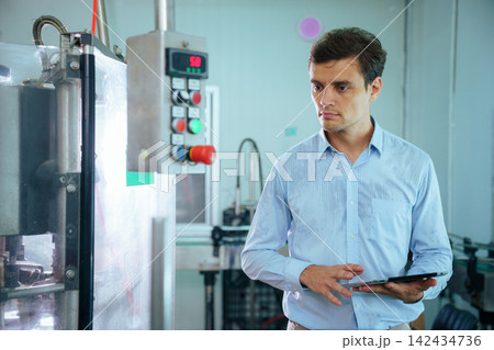 Focused male engineer using digital tablet on factory production line Focused male engineer using digital tablet on factory production line 142434736