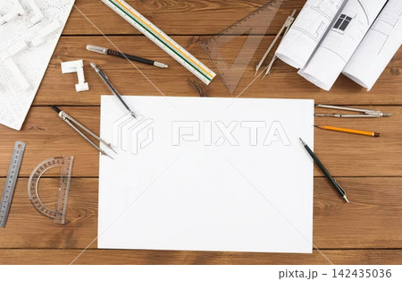 Architectural model with blueprints and drawing tools on wood 142435036