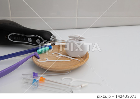 From minimal to expanded dental care: tools on a wooden tray in a home bathroom 142435073