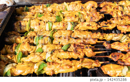 Delicious shish kebab with vegetables. Grilled BBQ pork. Skewer meat cooking on barbecue, shashlik. Shish kebab on skewer. Chicken on BBQ grill. Barbecue grill. Grilled chicken shish kebab Delicious shish kebab with vegetables. Grilled BBQ pork. Skewer meat cooking on barbecue, shashlik. Shish kebab on skewer. Chicken on BBQ grill. Barbecue grill. Grilled chicken shish kebab 142435286