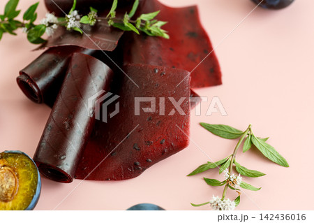 Plum snack rolls on pastel background Plum snack rolls on pastel background 142436016
