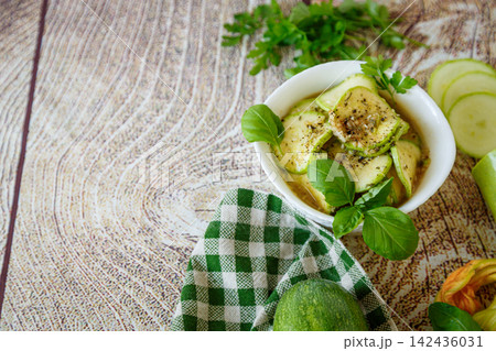 Seasoned zucchini slices with basil on rustic wooden background 142436031