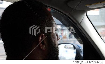 Confident bearded man looking concentrated to urban road while riding electric automobile. Guy driving the auto at highway. Serious male driver operating a motor car at town. Slow motion Confident bearded man looking concentrated to urban road while riding electric automobile. Guy driving the auto at highway. Serious male driver operating a motor car at town. Slow motion 142436612