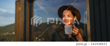Young woman with coffee outdoors, weekend away in container house in countryside. Young woman with coffee outdoors, weekend away in container house in countryside. 142436631