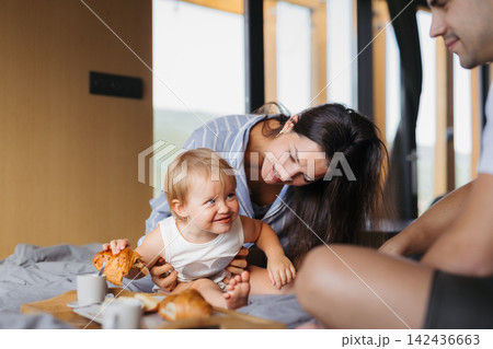 Young woman with husband and baby indoors, weekend away in small cotage n countryside. 142436663