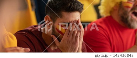 Worried football fans supporting spanish national team in live soccer match at stadium. Worried football fans supporting spanish national team in live soccer match at stadium. 142436848