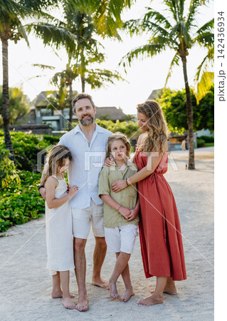 Parents and kids spending summer vacation in tropical beach resort. 142436934