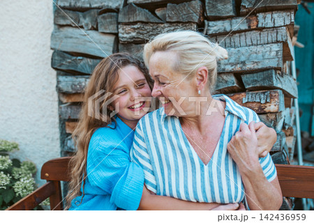 Grandmother and granddaughter hugging in the garden. Grandmother and granddaughter hugging in the garden. 142436959