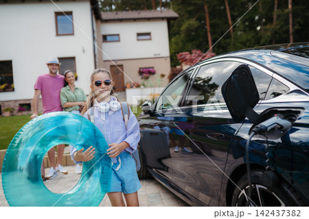 Happy family leaving home for summer vacation with luggage and pool toys. 142437382
