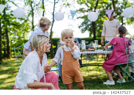 Potrait of young family during grill garden party. Potrait of young family during grill garden party. 142437527