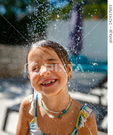 Happy girl taking shower after swimming in pool. 142437603