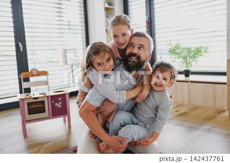 Playful father enjoying family time with his daughters at home. 142437761