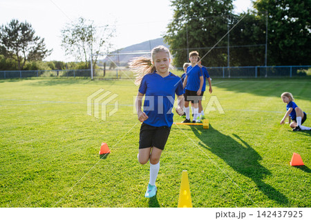 Young athletes training footwork and coordination on soccer field. Young athletes training footwork and coordination on soccer field. 142437925