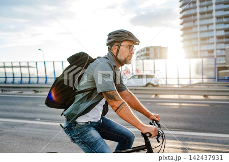 Male cyclist riding bike down the street. Male cyclist riding bike down the street. 142437931