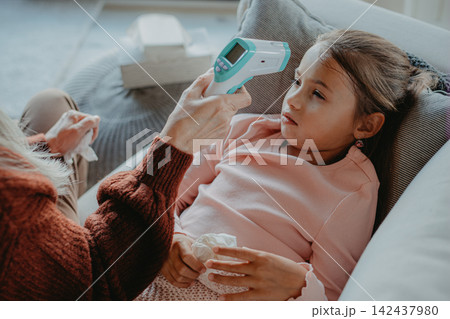 Grandfather taking care of his ill granddaughter lying in bed. Grandfather taking care of his ill granddaughter lying in bed. 142437980