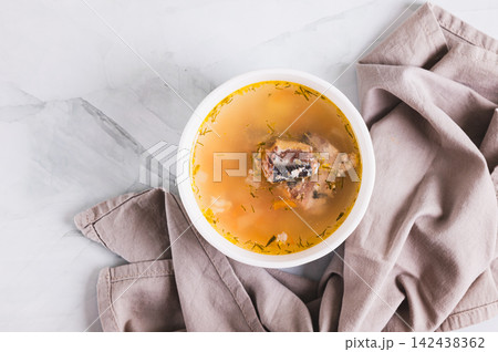Close up of simple budget soup with canned sardines and vegetables in a bowl on the table top view Close up of simple budget soup with canned sardines and vegetables in a bowl on the table top view 142438362