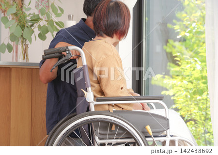 車椅子の妻に寄り添う中高年の夫 142438692