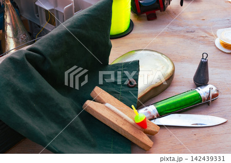 Fishing equipment close up with various tackle items, including lines, bobbers, and a reel, ready for a relaxing outdoor fishing trip. Fishing equipment close up with various tackle items, including lines, bobbers, and a reel, ready for a relaxing outdoor fishing trip. 142439331
