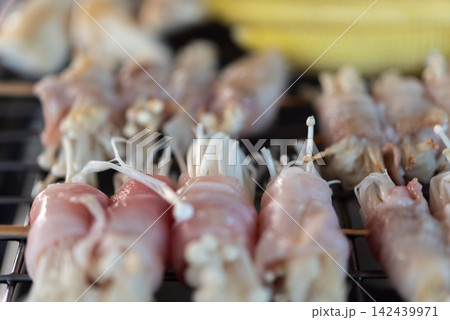 Bacon wrapped enoki mushrooms arranged grill ready for cooking as savory appetizer tender mushrooms rich pork flavor 142439971