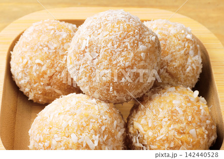 Brazilian coconut beijinho coated in shredded coconut. A dessert for parties, celebrations, and confectionery shops. Brazilian coconut beijinho coated in shredded coconut. A dessert for parties, celebrations, and confectionery shops. 142440528
