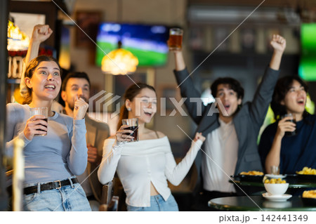 group of people in a sports bar rejoicing at the teams win 142441349