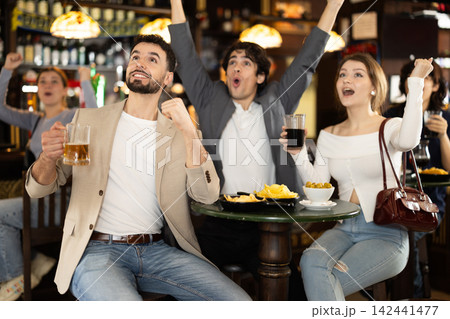 group of people in a sports bar rejoicing at the teams win group of people in a sports bar rejoicing at the teams win 142441477