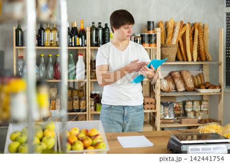 Man checking documents behind the counter Man checking documents behind the counter 142441754