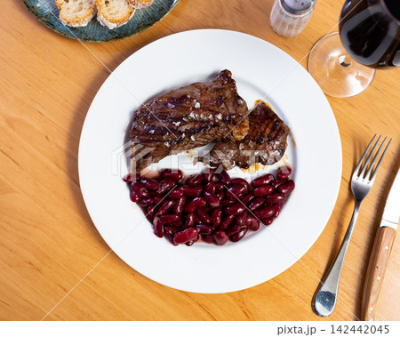 Ternera - traditional spanish grilled beef with beans on ceramic plate 142442045