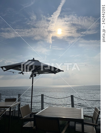 海辺のパラソルと雲間から差し込む光 海辺のパラソルと雲間から差し込む光 142442091