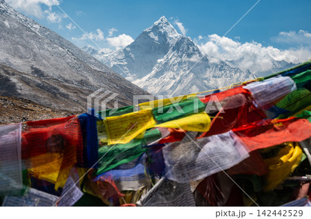 Beautiful view of Mt.Ama Dablam (6,812 m) looking through the prayer flags hanging on Thukla pass (4,830 m) a high mountain pass located in the Everest Trekking Region of Nepal. 142442529