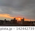 歩道橋から雨雲に追われる夕陽を見る 142442739