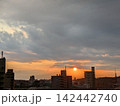 歩道橋から雨雲に追われる夕陽を見る 142442740