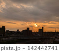 歩道橋から雨雲に追われる夕陽を見る 142442741