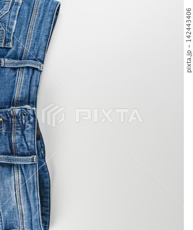 Closeup of a denim garment with pockets on a neutral background Closeup of a denim garment with pockets on a neutral background 142443406