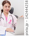 Professional doctor using laptop for telehealth, telemedical, online consultation and video meeting about Breast Cancer Awareness month, World Cancer Day and Pink October in hospital office concept 142444258