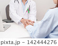 doctor hold patient hand to comfort and support with empathy. green and pink ribbon to patient for concept of October Metastatic Breast Cancer Awareness month, National Cancer Survivors Month 142444276