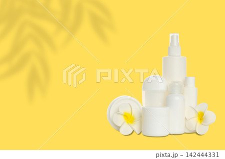 Cosmetics. Cosmetics laid out with toilet bag and delicate flowers on bright background Cosmetics. Cosmetics laid out with toilet bag and delicate flowers on bright background 142444331