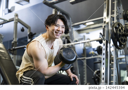 スポーツジムでトレーニングする若い男性 笑顔 スポーツジムでトレーニングする若い男性 笑顔 142445394