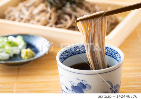 ざる蕎麦を麺つゆを付けて食べる 142446576