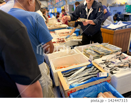 漁港の朝市で鮮魚を買う人々と活気ある市場の風景 漁港の朝市で鮮魚を買う人々と活気ある市場の風景 142447315
