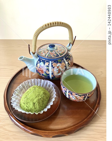 木製のお盆にのった抹茶おはぎと緑茶に美しい和柄の急須セット 木製のお盆にのった抹茶おはぎと緑茶に美しい和柄の急須セット 142448983